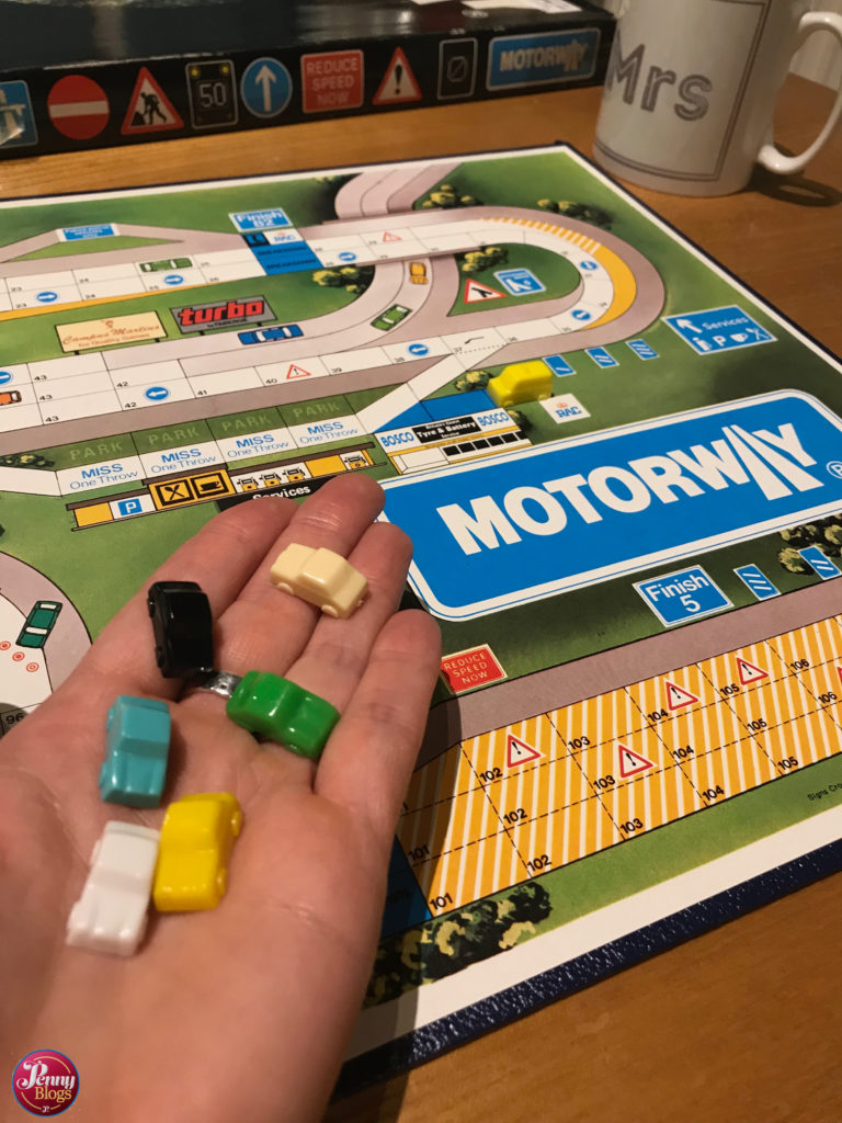 A section of the motorway board and the car shaped playing pieces.