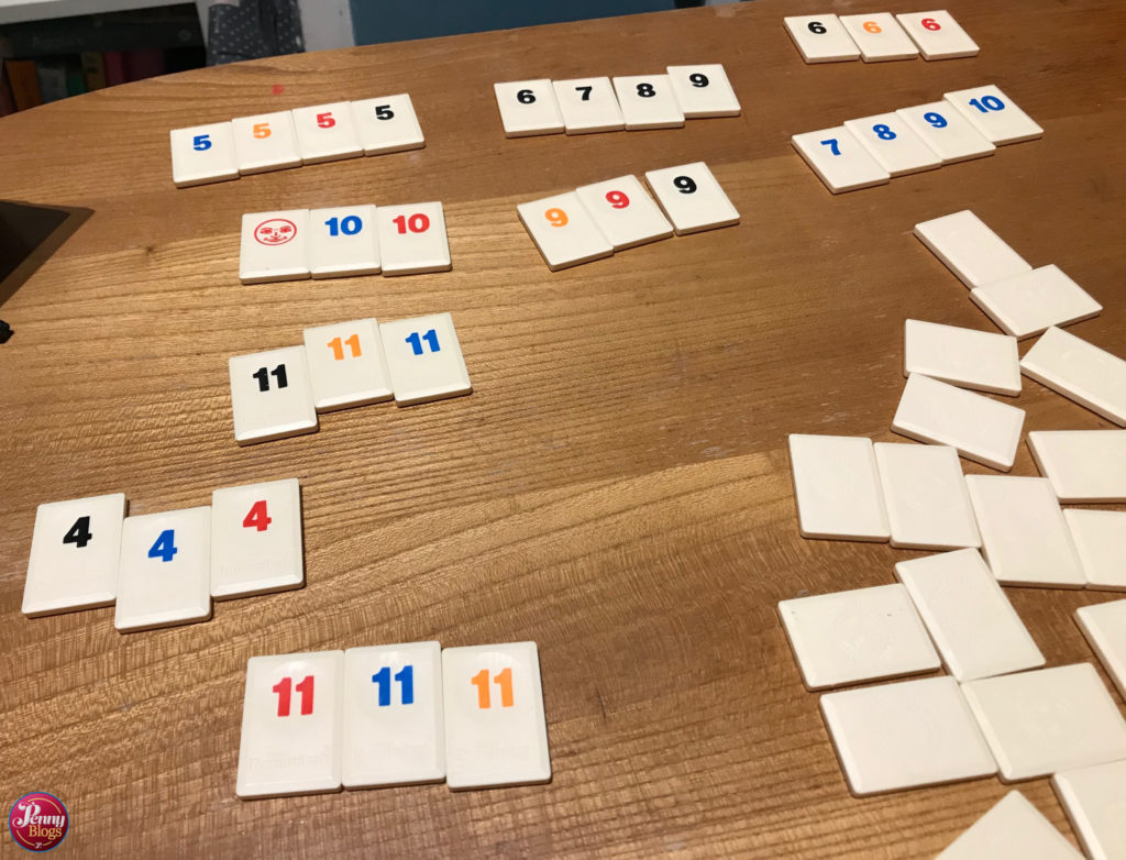 Rummikub tiles arranged in sets and runs on a table surface