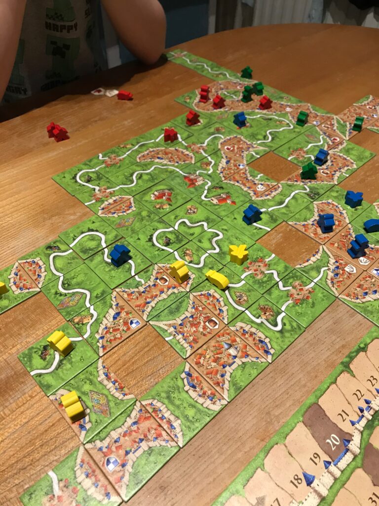 A view down at a table showing a game of Carcassonne in progress